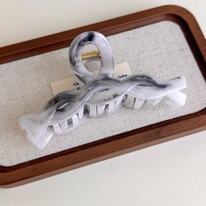 Detailed view of large grey ink marble hair claw with a premium golden metal spring