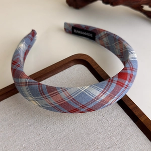 Macro view of handmade plaid fabric headband with classic blue and red tartan texture