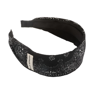 Detail view of a black paisley print headband featuring a handmade with heart label tag