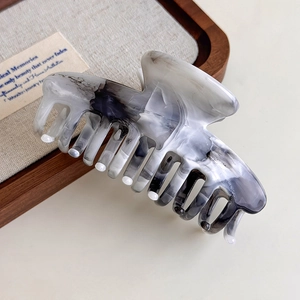 Detail of grey ink wash acetate hair claw clip showing smooth texture and marble pattern