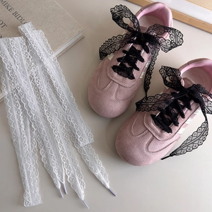 Baskets en daim rose avec nœuds en dentelle noir et blanc dans une esthétique vintage