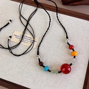 Ethnic beaded necklace with red agate beads and a woven black cord in vintage Chinese style