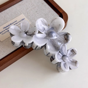 Macro detail of three grey marble ink flower hair claw clip with acetate resin texture