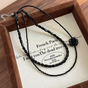 Close-up of a double-layered black rose beaded necklace with adjustable metal chain