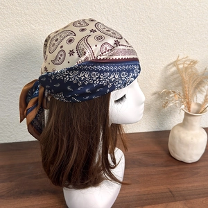 Detail showing the intricate paisley pattern and silk-like texture of the headscarf