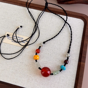 Ethnic style necklace with red agate beads and lotus charms on black braided cord