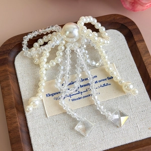 Dettaglio ravvicinato di un fiocco di perle per scarpe con nappe e cristalli