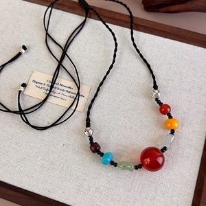Detailed macro view of retro ethnic beaded necklace with colorful agate and woven cord