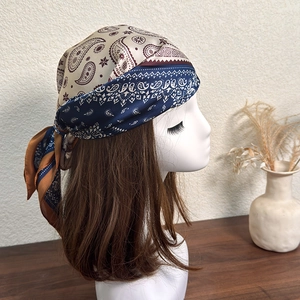 Detail of vintage paisley pattern headscarf with satin texture on a brunette model