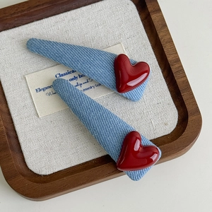 Set of two denim blue triangle hair clips with shiny red heart accents for girls