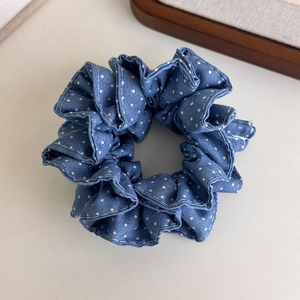 Close-up of retro navy blue polka dot denim scrunchie with layered ruffles