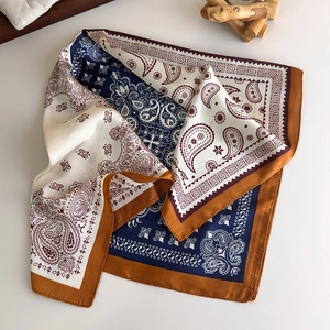 Close-up of paisley pattern square silk scarf with navy blue and caramel satin texture