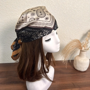 Detail of paisley print headscarf tied on a model head in a vintage aesthetic setting