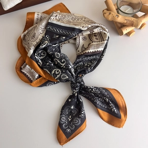 Flat lay of vintage paisley silk scarf with black and yellow geometric pattern details