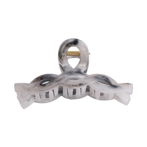 Macro detail of marble pattern hair claw clip with golden metal spring for women
