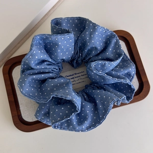 Detail of light blue polka dot denim scrunchie on a decorative wooden frame tray