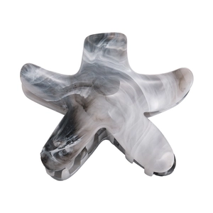 Detailed view of the starfish-shaped hair claw with grey marble ink pattern texture