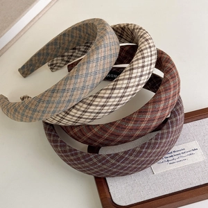 Detail view of four textured plaid padded headbands in earthy beige and brown tones