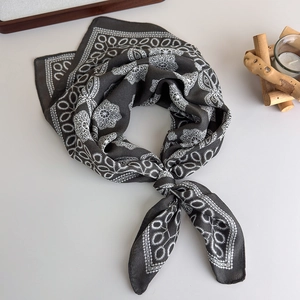 Detail of silk-like square scarf with retro grey paisley and white floral patterns
