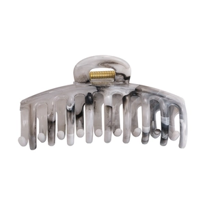 Detail of large ink-marbled acetate hair claw clip with golden metal spring for thick hair