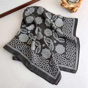 Detail of charcoal grey silk scarf with white geometric mandala floral patterns