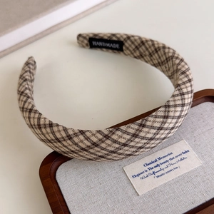 Close-up of handmade retro plaid headband with classic brown and beige woven texture