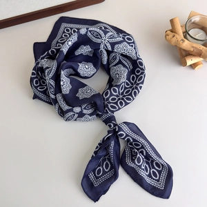 Detail of navy blue silk scarf with white lace patterns and geometric print
