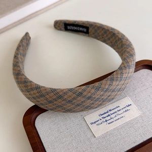 Detailed view of handmade plaid fabric headband with earthy tones and artisan label
