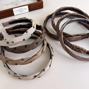 Detail of twisted fabric headband with plaid patterns and non-slip inner teeth design