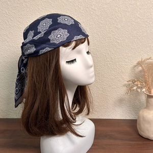 Close-up of navy blue bandana with white mandala lace patterns tied on a model head