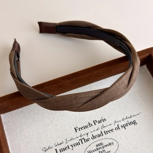 Detail view of vintage brown twisted fabric headband with internal anti-slip comb teeth