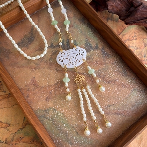 Detail of Chinese style pearl necklace with white hollow ruyi lock and long tassels