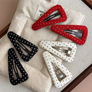Detailed set of polka dot fabric hair clips in red, black and white on canvas