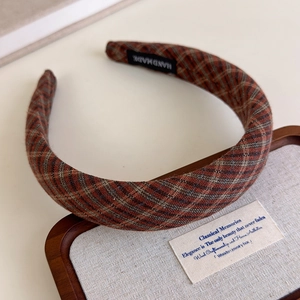 Detail of red and grey plaid headband showing thick handmade fabric texture on wood tray