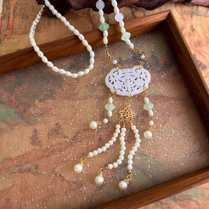 Detail of traditional Chinese Ruyi lock pendant necklace with long white pearl tassels
