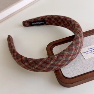 Detail shot of the vintage plaid headband with a woven HANDMADE label on fabric