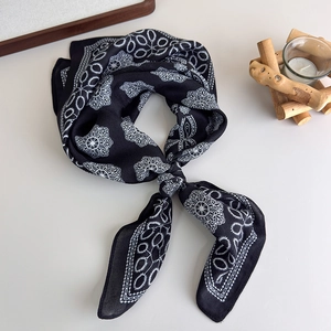Detail of printed silk square scarf featuring black and white mandala patterns with soft gloss