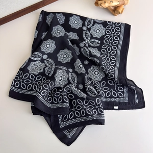 Detail of black silk scarf with white mandala patterns and high-quality hemmed edges