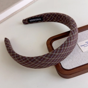 Close-up of retro plaid headband with dark brown fabric and handmade logo label detail