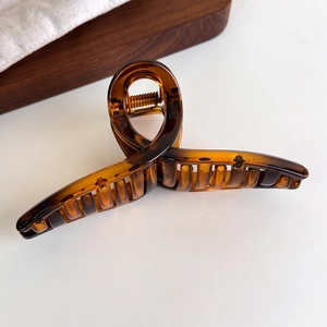 Detail einer großen bernsteinfarbenen Haarklammer mit glattem Spiral-Resin-Design