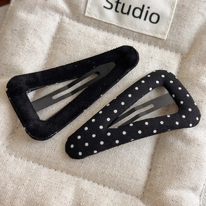 Detail of two-piece set including black velvet and polka dot fabric triangular hair clips