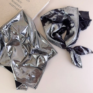 Close-up of silver metallic fabric bandana with high-gloss finish and pleated texture