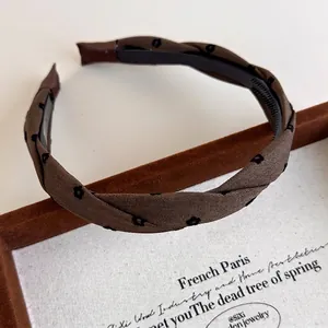 Detail of dark brown floral fabric headband with anti-slip inner teeth for secure hair grip