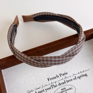 Close-up of vintage brown plaid headband showing textured fabric and twisted design details