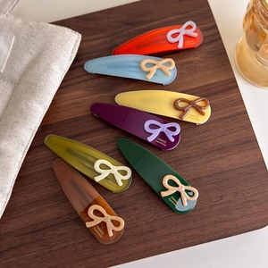 Detail view of 7-piece acetate bow hair clips set with gold France Handmade logo