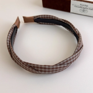 Detailed view of brown plaid headband with anti-slip inner teeth and fabric texture