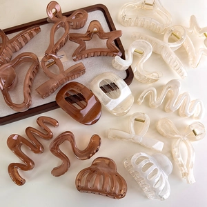 Assorted amber and cream acrylic hair claws in star and wave geometric shapes