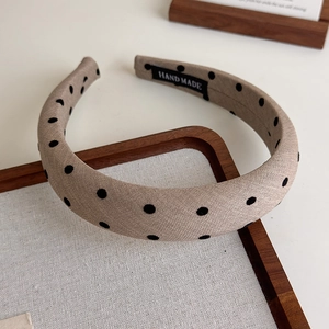 Vue détaillée du serre-tête en tissu à pois fait main avec une étiquette tissée