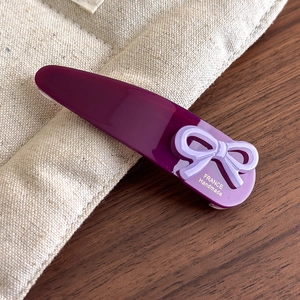 Detail showing Burgundy acetate hair clip with France Handmade gold lettering and bow