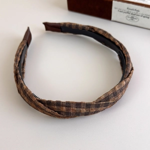 Detail view of brown plaid fabric headband showing the inner anti-slip teeth and texture